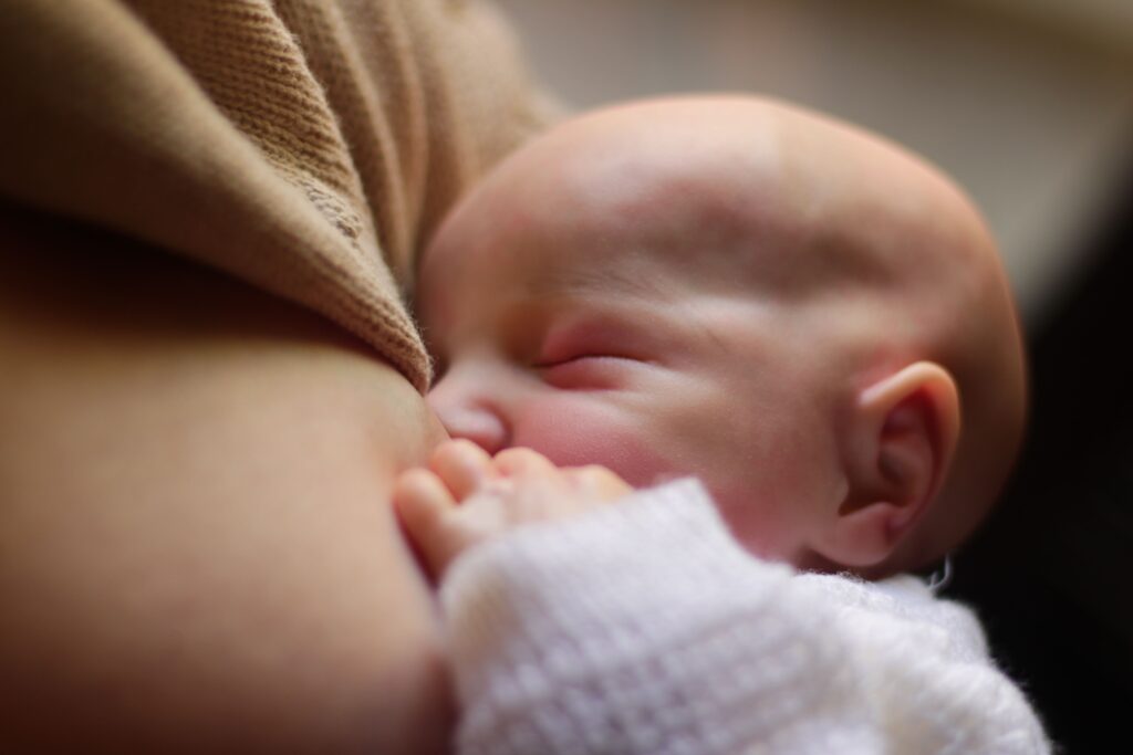 un bébé tète le sein de sa mère